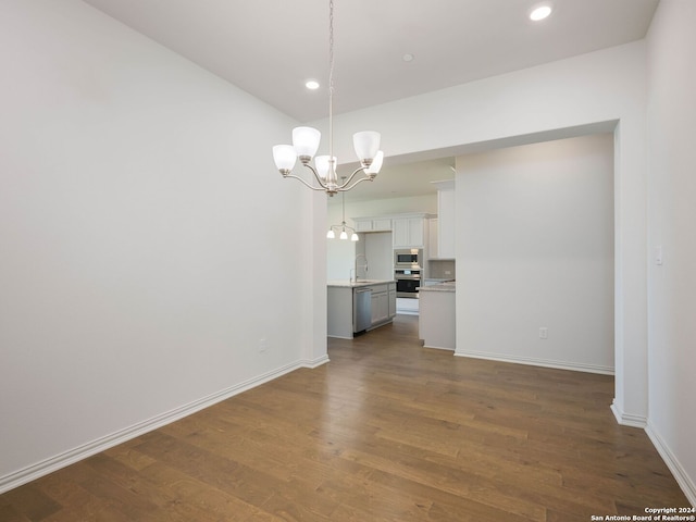 empty room with an inviting chandelier, sink, and dark hardwood / wood-style floors