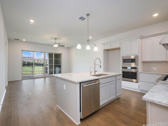 kitchen with white cabinets, appliances with stainless steel finishes, sink, and an island with sink