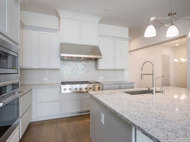 kitchen with tasteful backsplash, stainless steel appliances, dark hardwood / wood-style flooring, hanging light fixtures, and sink