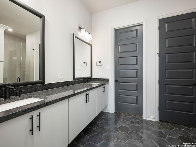 bathroom with tile floors, walk in shower, and double sink vanity