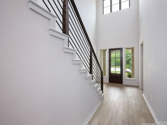 entryway with a towering ceiling and hardwood / wood-style floors