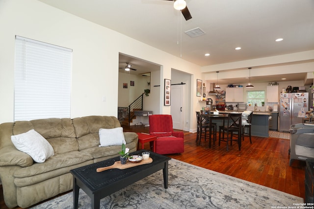 living room featuring dark hardwood / wood-style flooring and ceiling fan