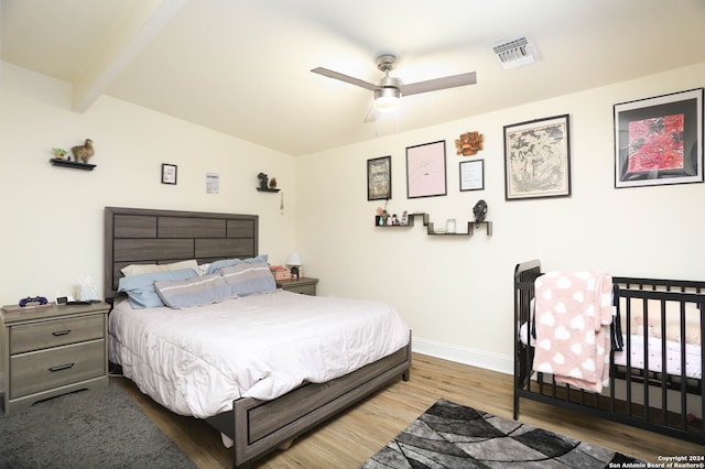 bedroom featuring ceiling fan, lofted ceiling with beams, and hardwood / wood-style floors