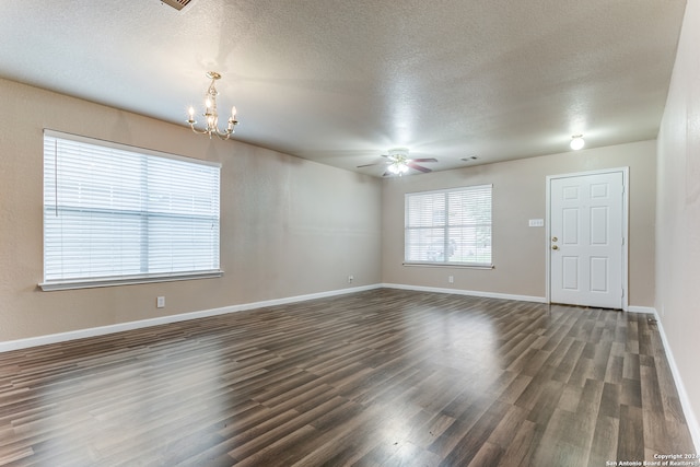 spare room with dark hardwood / wood-style flooring, a textured ceiling, and ceiling fan with notable chandelier