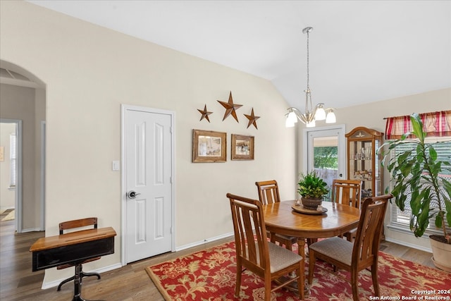 dining room featuring a notable chandelier, vaulted ceiling, and hardwood / wood-style floors