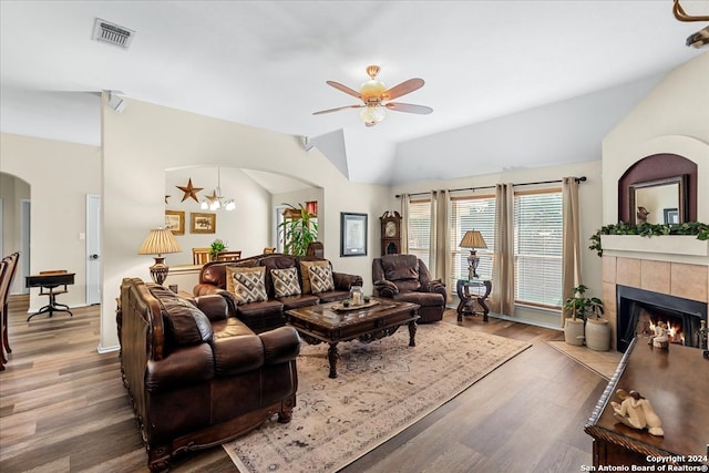 living room featuring a fireplace, ceiling fan, hardwood / wood-style floors, and vaulted ceiling