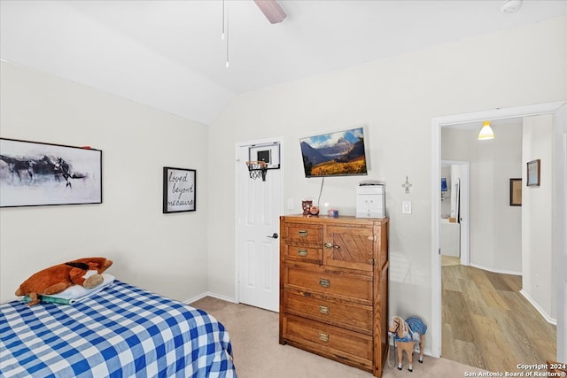 bedroom with ceiling fan, vaulted ceiling, and light wood-type flooring