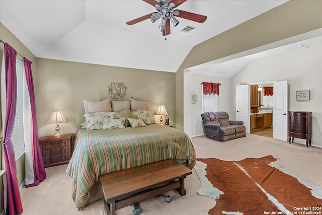 bedroom with ceiling fan, light carpet, connected bathroom, and vaulted ceiling