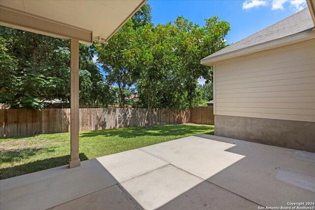 rear view of house with ceiling fan and a lawn