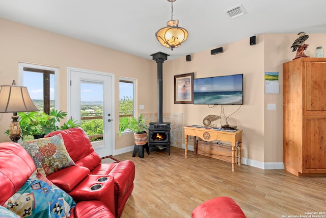 living room with light hardwood / wood-style floors and a wood stove