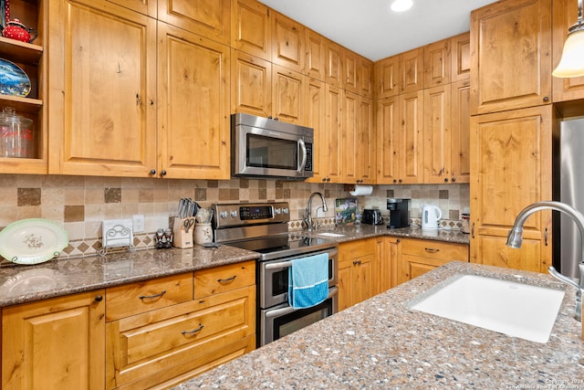 kitchen with sink, backsplash, stone countertops, and stainless steel appliances