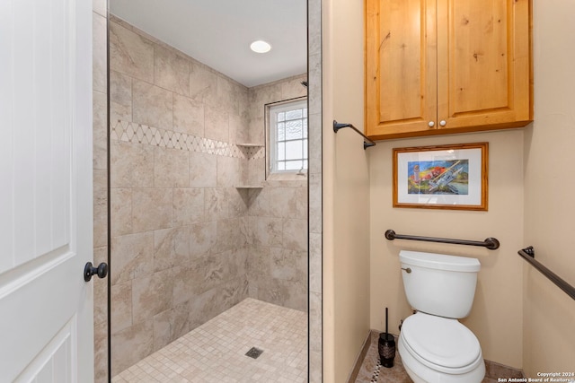 bathroom featuring tiled shower and toilet