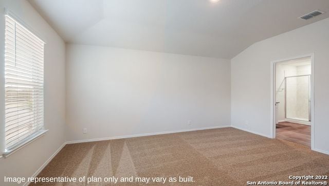 carpeted spare room with lofted ceiling