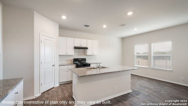 kitchen featuring dark hardwood / wood-style flooring, black range with gas cooktop, sink, white cabinets, and an island with sink