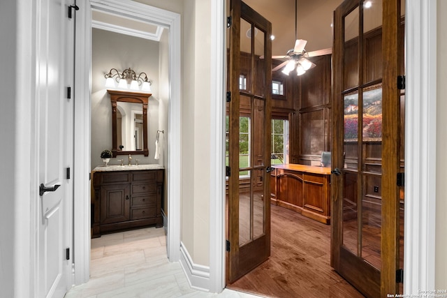 bathroom with ceiling fan, wood-type flooring, ornamental molding, and vanity