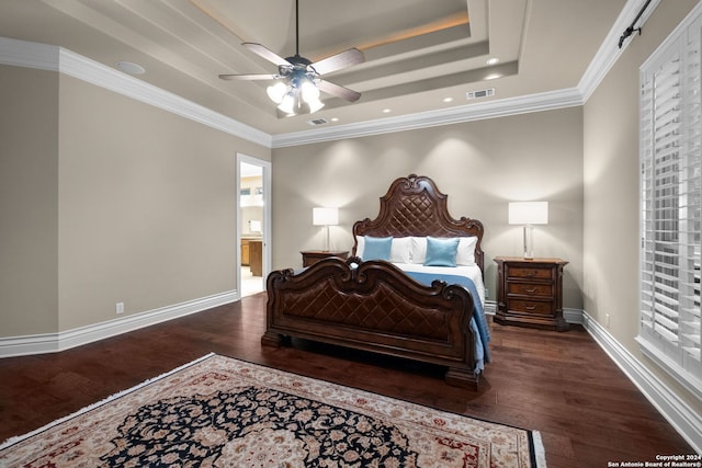 bedroom with dark hardwood / wood-style floors, ceiling fan, a raised ceiling, crown molding, and connected bathroom