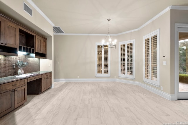 kitchen featuring ornamental molding, stone counters, backsplash, and an inviting chandelier