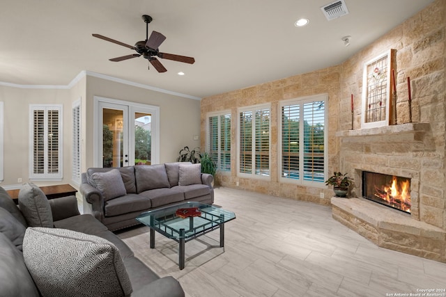 living room with ceiling fan, crown molding, a fireplace, tile walls, and light tile floors