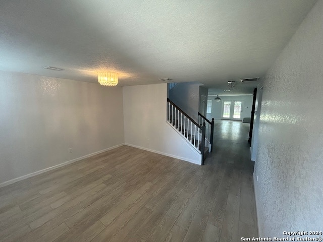 unfurnished room with a textured ceiling and dark wood-type flooring