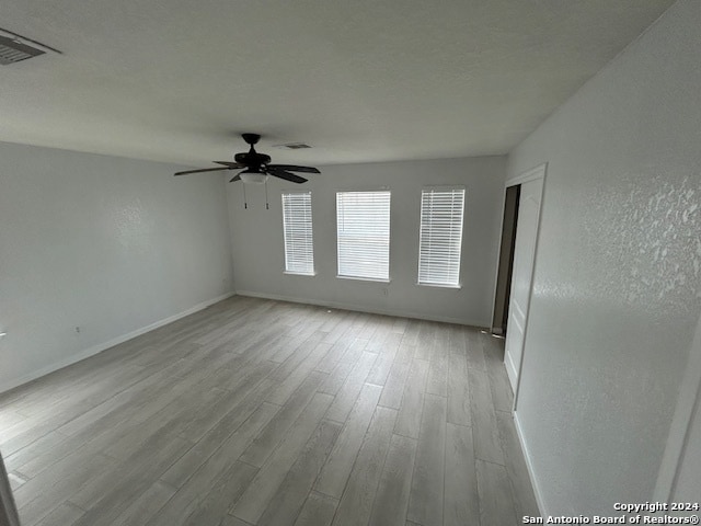 unfurnished room with ceiling fan and light wood-type flooring