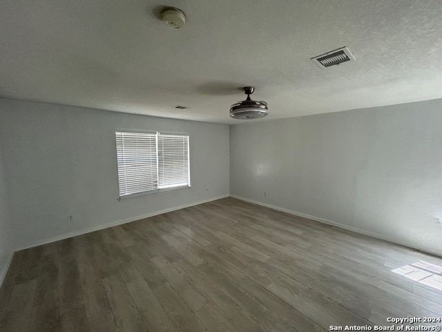 spare room with a textured ceiling and hardwood / wood-style flooring