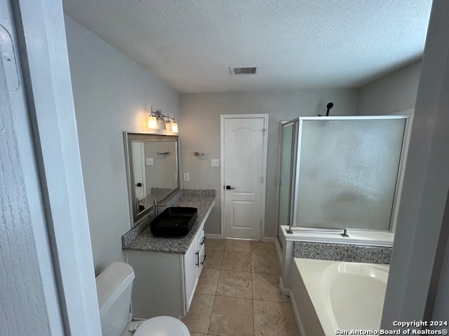 full bathroom with toilet, tile flooring, large vanity, a textured ceiling, and plus walk in shower