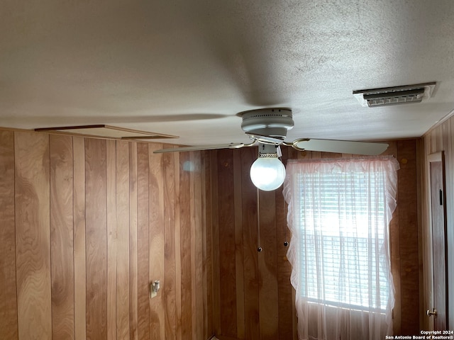 details with wooden walls and a textured ceiling