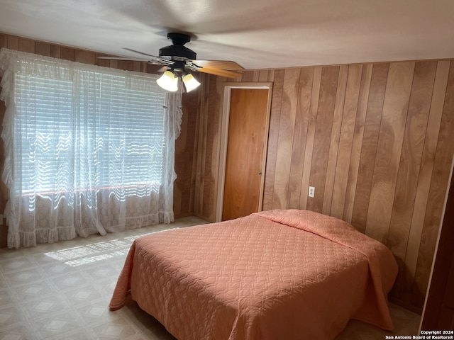 bedroom with wooden walls and ceiling fan