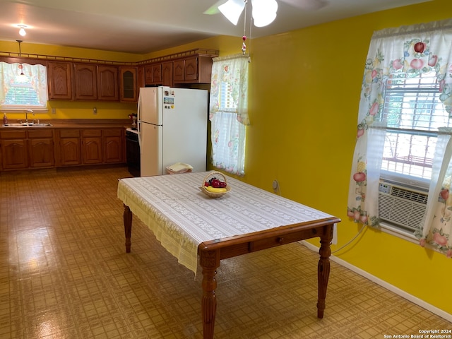 kitchen featuring white refrigerator, hanging light fixtures, ceiling fan, sink, and light tile floors