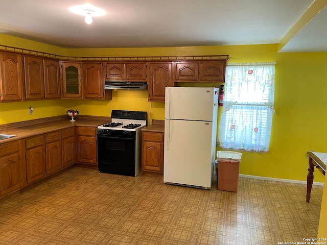 kitchen with extractor fan, white appliances, and light tile floors