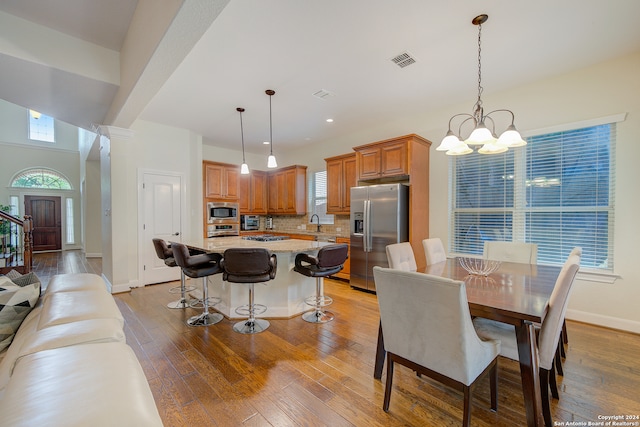 dining room with sink, hardwood / wood-style flooring, and a chandelier