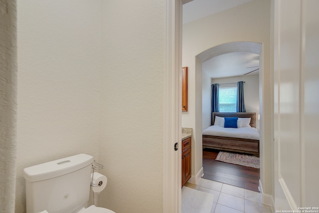 bathroom with toilet, ceiling fan, vanity, and hardwood / wood-style flooring