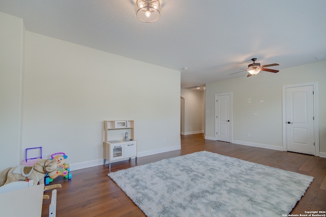 living area with dark wood-type flooring and ceiling fan