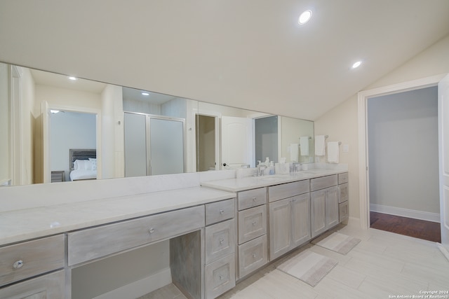 bathroom with tile flooring, vanity, and lofted ceiling