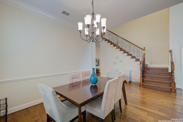 dining room featuring crown molding, an inviting chandelier, and hardwood / wood-style floors