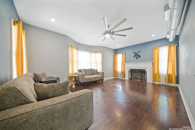 living room with wood-type flooring, ceiling fan, and a fireplace