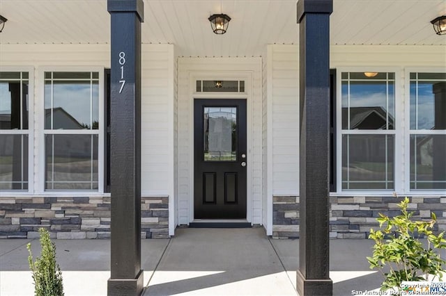 view of exterior entry featuring covered porch