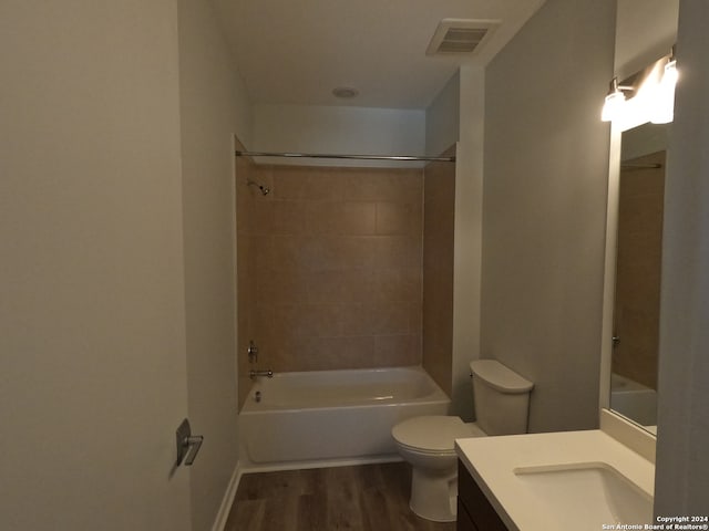 full bathroom with tiled shower / bath combo, oversized vanity, toilet, and wood-type flooring