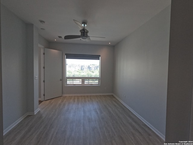 unfurnished room featuring dark wood-type flooring and ceiling fan