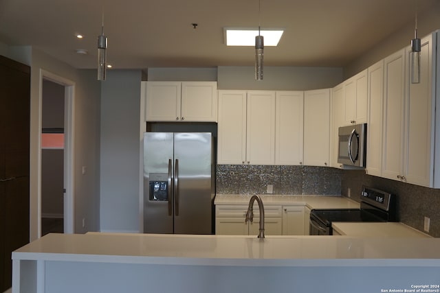 kitchen featuring stainless steel appliances, white cabinetry, tasteful backsplash, and pendant lighting