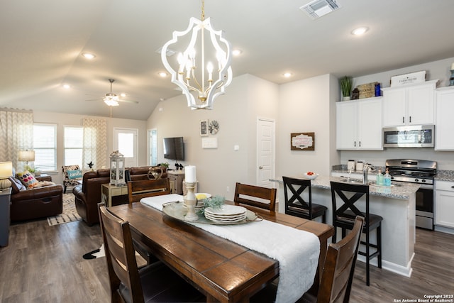 dining room featuring dark hardwood / wood-style floors, lofted ceiling, and ceiling fan with notable chandelier