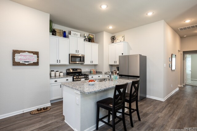 kitchen with stainless steel appliances, dark wood-type flooring, and white cabinetry