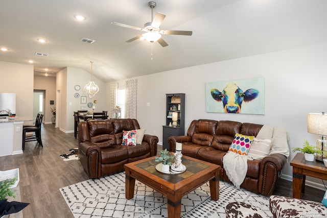 living room with vaulted ceiling, hardwood / wood-style floors, and ceiling fan with notable chandelier