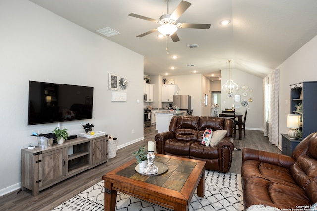 living room with lofted ceiling, wood-type flooring, and ceiling fan with notable chandelier