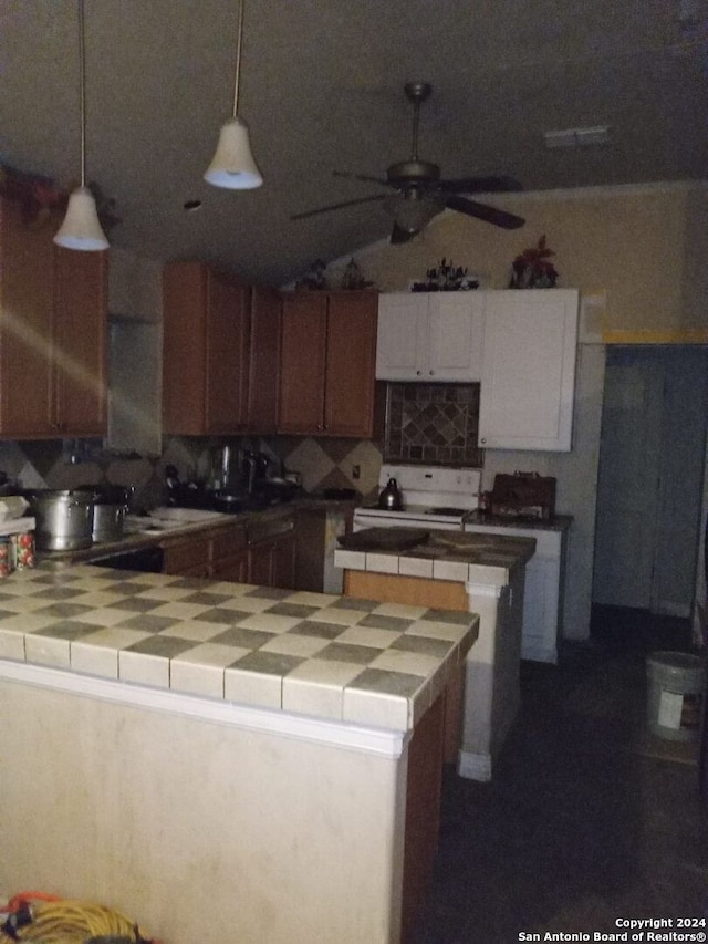 kitchen with hanging light fixtures, stove, ceiling fan, and tile countertops