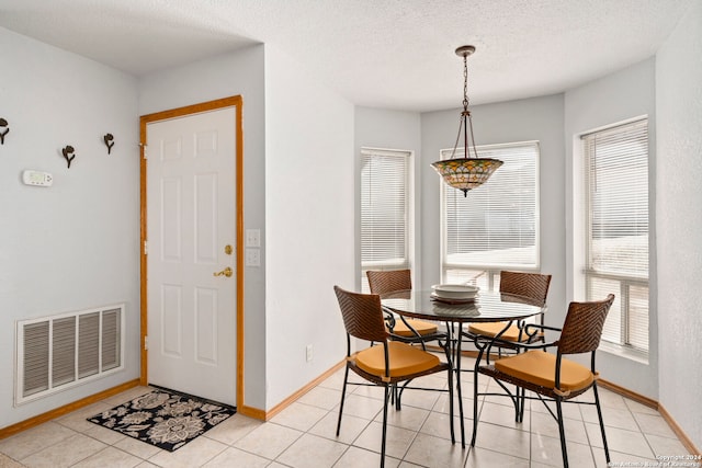 tiled dining area with a textured ceiling