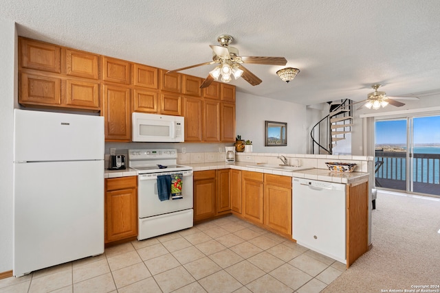 kitchen with light colored carpet, ceiling fan, white appliances, and kitchen peninsula