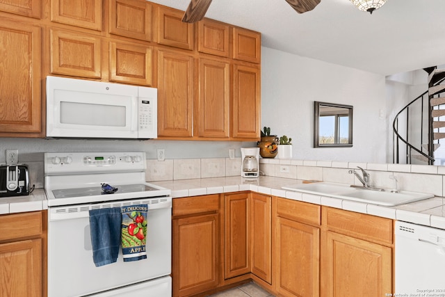 kitchen with sink, tile countertops, ceiling fan, and white appliances