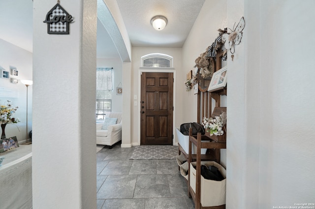 tiled entrance foyer with a textured ceiling