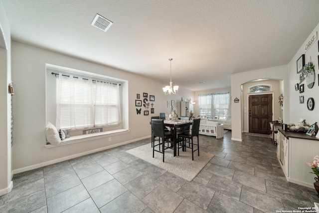 tiled dining space with a chandelier